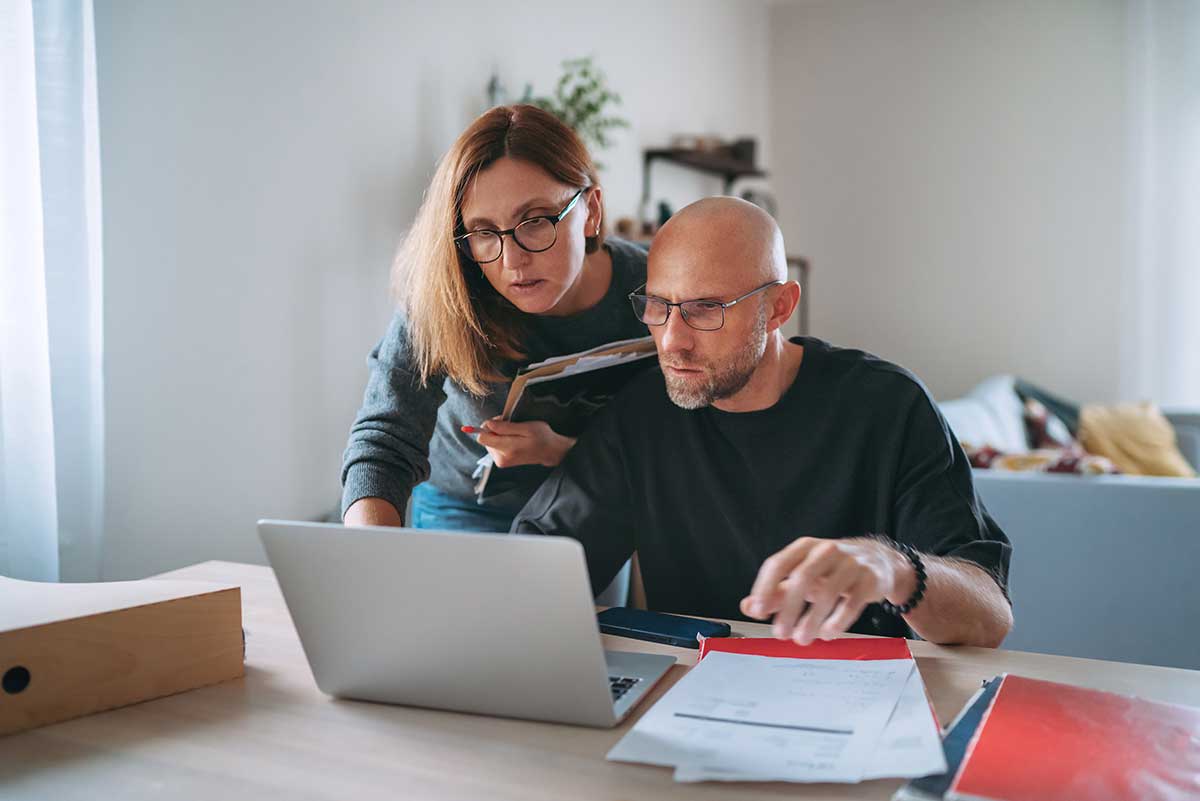 Couple reviewing finances on laptop.