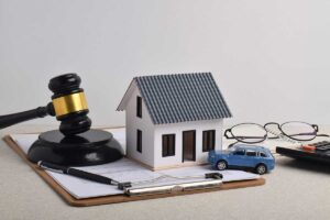 Gavel, house model, car, paperwork.